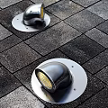 Two Modern Metallic Floor Lamps With Bright Glow On Paved Ground