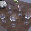 Clear Wine Glasses Arranged On Brown Table With Decorative Vase And White Flowers