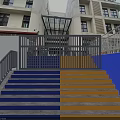 Colorful Staircase With Blue And Yellow Steps Metal Railings And White Walls