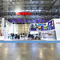 Yamaha Modern Exhibition Booth Featuring White Vehicle Blue Carpet And Purple Decorations