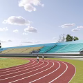Outdoor Stadium With Red Running Track Green Lawn And Blue Spectator Stands