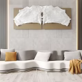 Curved Sofa with Amber White Pillows and Brown Wall Art on Wooden Floor