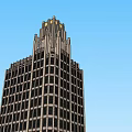Tall Modern Skyscraper With Ornate Top Design Against Clear Blue Sky
