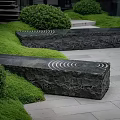 Garden Ornaments With Spiral Patterned Stone Slabs Lush Green Grass And Trimmed Shrubs