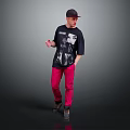 Man wearing cap black T-shirt with graphic print pink pants standing dark background