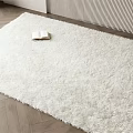 White Square Shaggy Rug on Herringbone Wooden Floor with Open Book and Vertical Striped Wall
