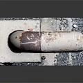 Rusty Pipe Elbow Mounted On Concrete Base With Small Metal Pieces Around 3d model