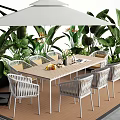 Outdoor Wooden Table With White Umbrella And Wicker Chairs In Garden With Green Plants