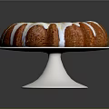Delicious Round Bundt Cake With White Icing Drizzle On Silver Stand Against Dark Background