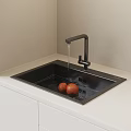 Modern Kitchen Black Washing Sink with Running Water Faucet and Oranges on White Countertop
