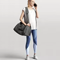 Woman in White T-shirt and Blue Leggings Carrying Gray Large Bag on Gray Background