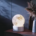 Moon Shaped Table Lamp with Concrete Base Emitting Warm Soft Glow in Modern Room