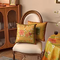 Yellow Floral Decorative Pillows on Vintage Wooden Chair with Floral Tablecloth Wine and White Orchid