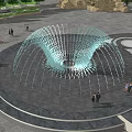 Outdoor Public Square Fountain With Circular Layout Water Sprays And People Around Trees