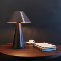Modern Table Lamp Featuring Dark Leather Shade On Wooden Table With Coffee Cup And Books