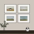 Four Framed Landscape Paintings Hanging On Wall With Green Plant And Alarm Clock