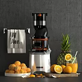 Modern Electric Juicer With Fresh Pineapple Oranges And Towel On Gray Background