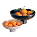 Fresh Ripe Oranges Arranged in Black and White Bowls with Green Leaves