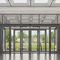 Modern Glass Entrance With Automatic Doors Reflecting Green Lawn And Trees