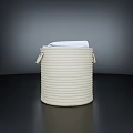 White Towel Peeking Out of a Round White Woven Storage Basket