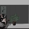 A Woman Sitting On Bed With Framed Posters Gray Wall Floor Lamp And Potted Plant