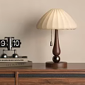 Beige Pleated Lampshade Wooden Base Table Lamp With Black Clock And Books On Wooden Cabinet