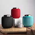 Colorful Ceramic Vessels With Vertical Stripes And Silver Lids On Wooden Table