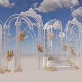 Elegant Event Entrance With White Arches Golden Flowers Against Blue Sky White Clouds And Steps