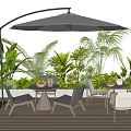 Outdoor Table With Parasol And Chairs On Wooden Deck Surrounded By Green Plants