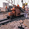 Industrial Utility Vehicle Working At Construction Site With Workers And Cranes