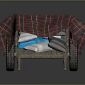 Wooden Wheelbarrow Covered With Red And Black Plaid Cloth And Blue White Items Inside
