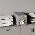 Office Equipment With White Printer Gray Label Printer And Black File Holder On Gray Cabinet
