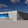 Futuristic Building With Honeycomb Exterior And Large Digital Display Under Blue Sky Clouds