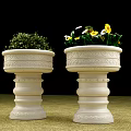 Roadside Stone Flower Planters With Intricate Carvings Holding Greenery And Yellow Blooms