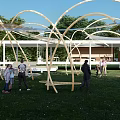 Tensile Membrane Structure In Outdoor Park With Green Grass People Activities And Sunset Sky