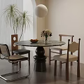 Round Marble Top Dining Table With Black Base Four Chairs Green Plants And Flower Arrangement