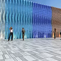 Modern Colorful Feature Wall With Blue Brown Wavy Panels And People Standing