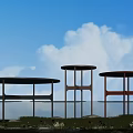 Round Coffee Tables In Three Different Colors With Blue Sky White Clouds Grass And Water