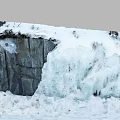 Garden Landscape With Thick Snow On Rocks And Cascading Ice Waterfall