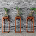 Bonsai Plants Displayed On Red Wooden Plant Stands Against Gray Brick Wall