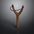 Wooden Y Shaped Slingshot With Black Rubber Band Isolated On Dark Background