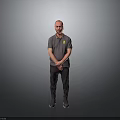 Man Standing in Gray Polo Shirt with Yellow Logo and Hands Crossed on Gray Background