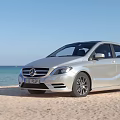 Various Cars Parked On Sandy Beach With Ocean And Blue Sky View