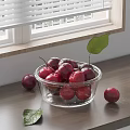Juicy Red Plums in Glass Bowl on Wooden Countertop with Green Leaves and Window Blinds