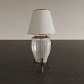 Modern Table Lamp With White Lampshade Transparent Glass Body And Metallic Base On Dark Tabletop