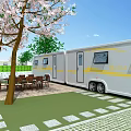 Scenic Outdoor Caravan Area With Cherry Blossom Trees Dining Table Paved Patio And Green Grass