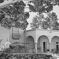 Traditional Courtyard Garden Featuring Arches Lush Greenery Trees And Outdoor Seating