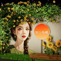 Art Installation With Female Figure Adorned By Green Vines And Yellow Sunflowers On Wall