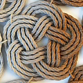 Collection of Braided Knot Shaped Rugs Neatly Arranged On White