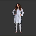 A Woman in White Coat and Pants Standing with Hands on Hips Against Gray Background